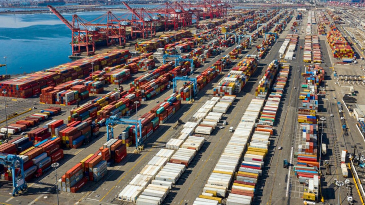 Aerial view of busy container port with shipping containers, cranes, and trucks representing global logistics challenges