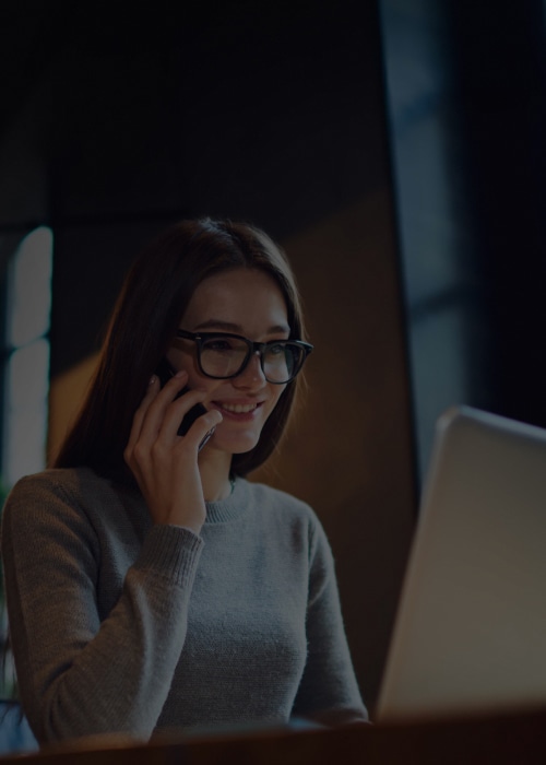 Woman on a phone call with the Maersk Destination Coordination Services team in front of a laptop.