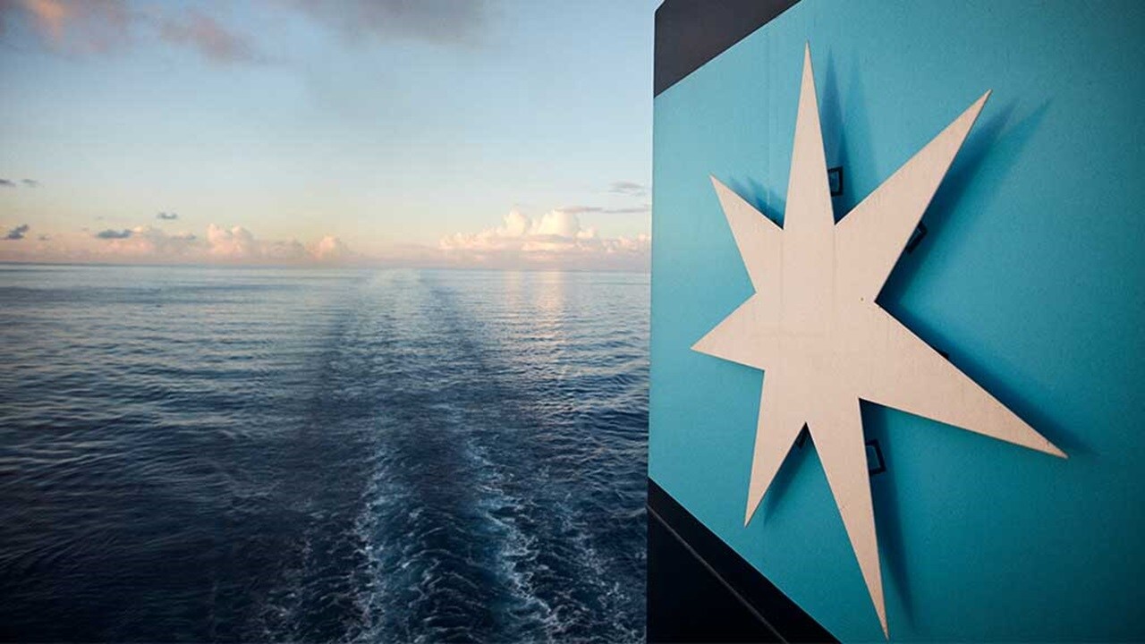 Ship at sea with Maersk star emblem and calm waters.