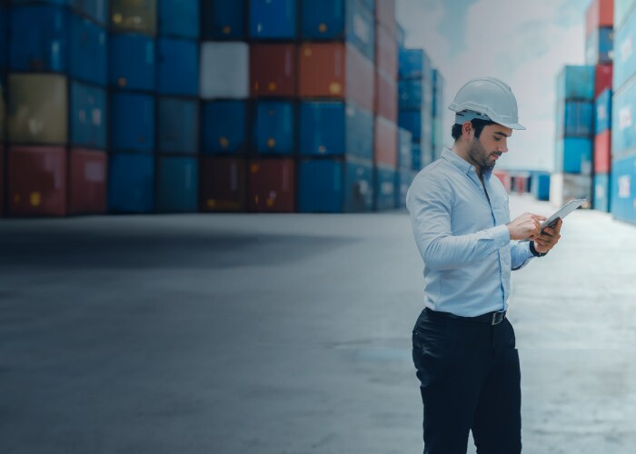 A large group of stacked Maersk group containers at a port or terminal