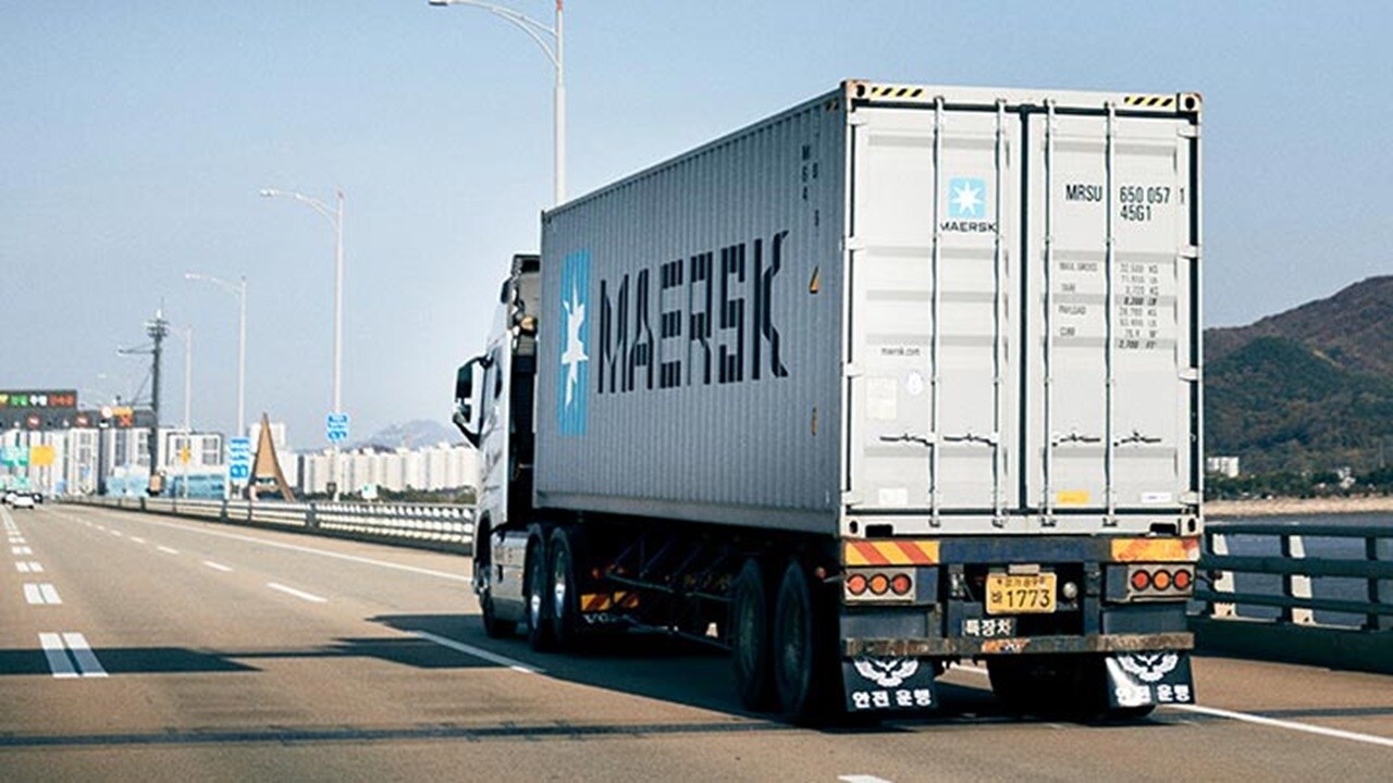 Maersk container truck transporting cargo on a highway for logistics and freight services.