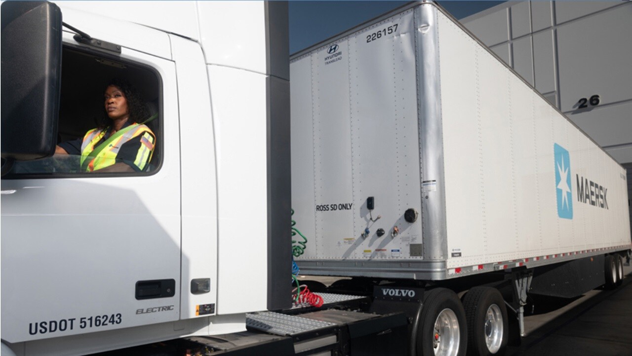 Женщина-водитель грузовика проверяет зеркало заднего вида перед началом поездки