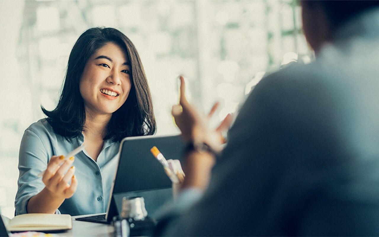 A smiling woman holding a digital device.